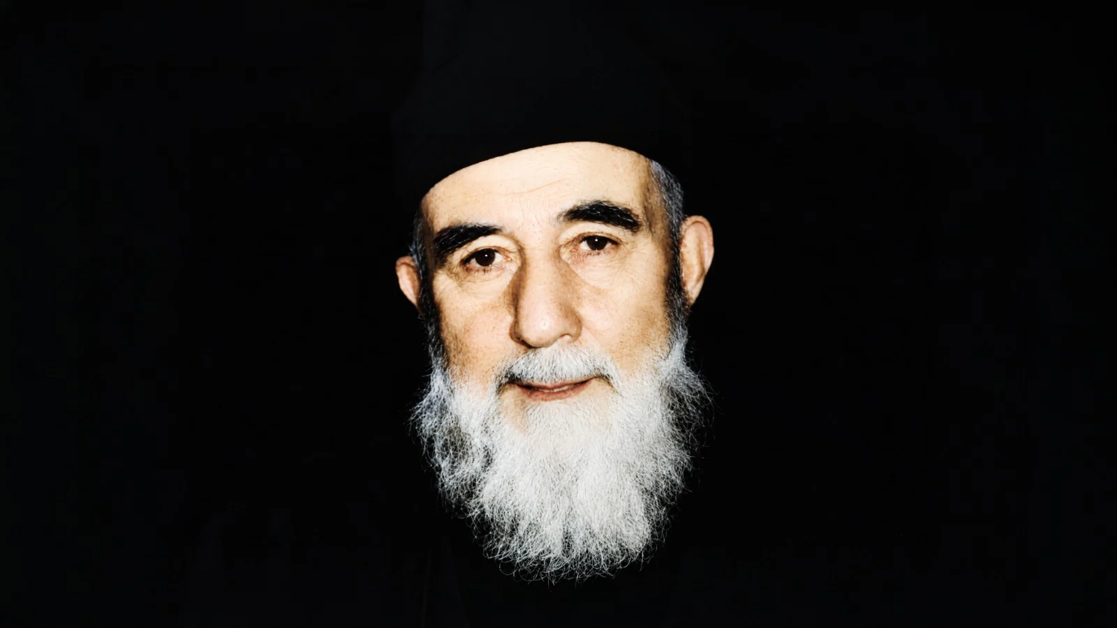 Mehmed Zahid Kotku in his later years, white-bearded, against a dark ground