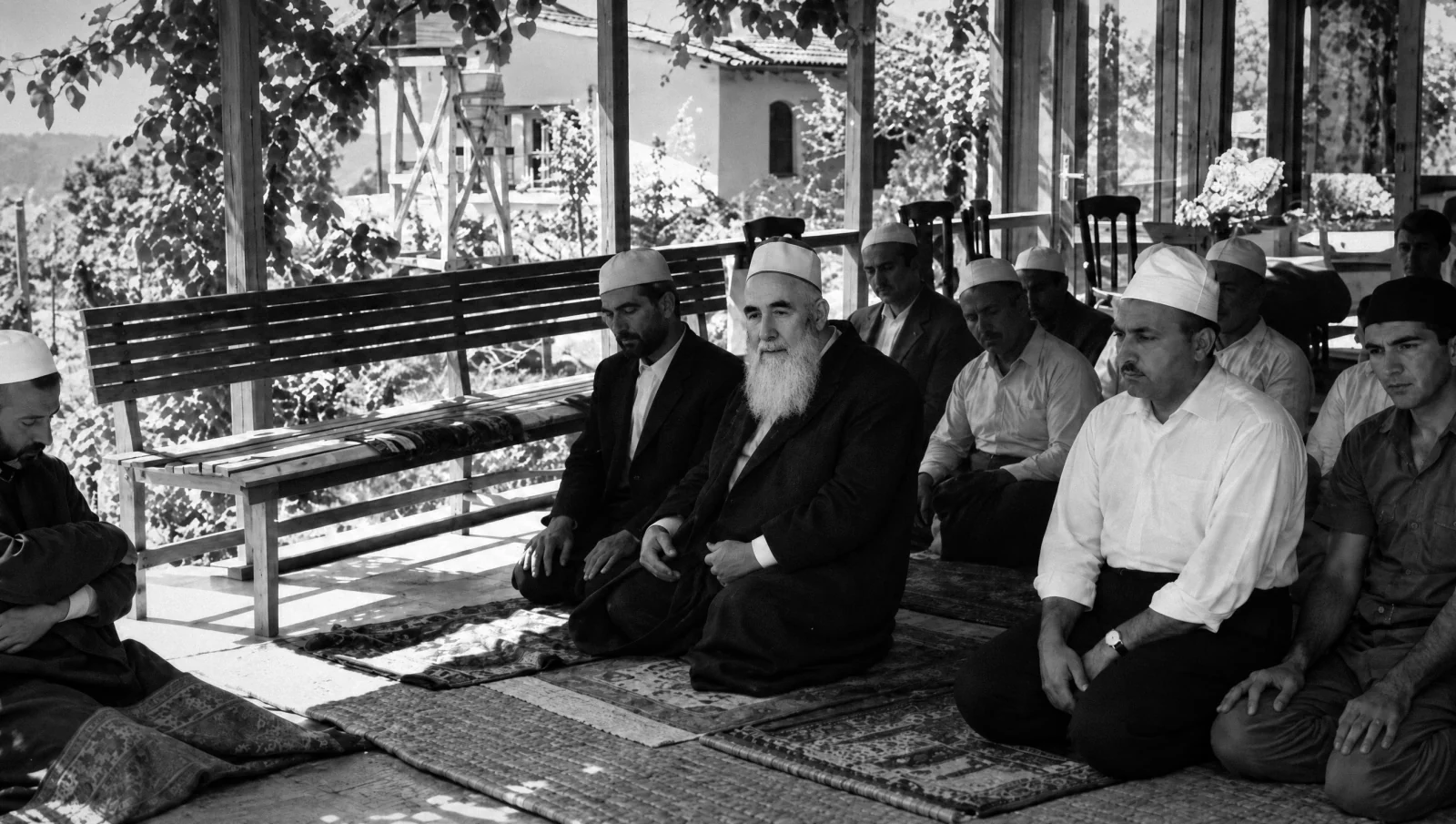 Mehmed Zahid Kotku kneeling in prayer among his students on a veranda